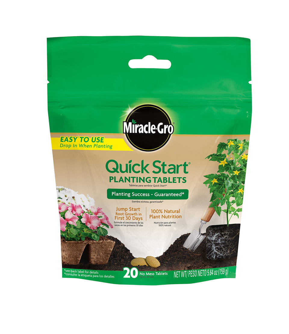 Miracle-Gro Quick Start tablets being placed in a planting hole for root growth