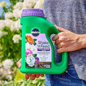 Miracle-Gro Shake 'n Feed granules spread on dry soil for quick feeding