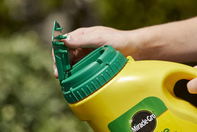 Miracle-Gro Shake 'N Feed weed prevention demonstrated in a garden bed.