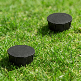 Mizelu black sprinkler head cap outdoors, emphasizing discreet, weather-ready cover.