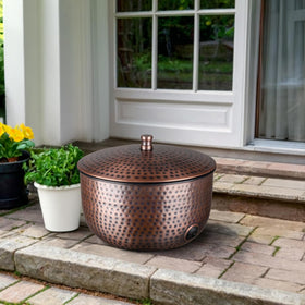 Monarch Abode hand-hammered metal hose holder for durable outdoor use.
