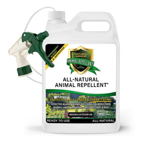Natural Armor repellent spray bottle actively deterring pests near a garden.