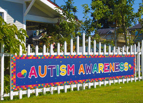 Nepnuser autism banner puzzle piece for outdoor display on a fence.