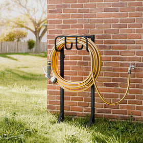 Niffgaff garden hose holder stand in use in a yard setting