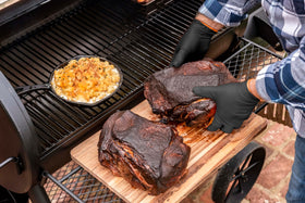 Hands wearing liners under nitrile gloves while handling hot food.