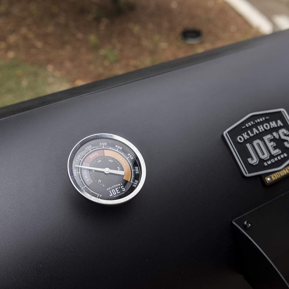 Oklahoma Joe's temperature gauge in use inside a smoker during barbecue session