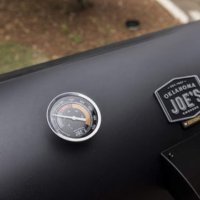 Oklahoma Joe's temperature gauge in use inside a smoker during barbecue session