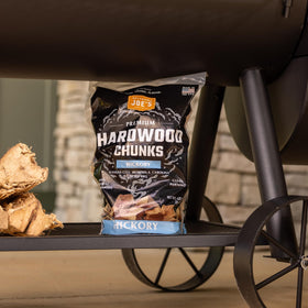 Oklahoma Joe's Hickory wood chunks with meats board highlighting versatile smoke seasoning.