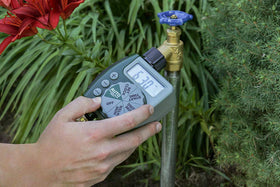 Orbit watering timer on faucet demonstrates quick setup for automated watering at home.