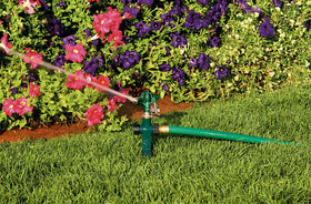 Orbit zinc step spike anchored in soil for stable watering.