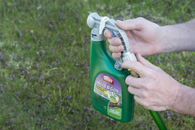 Ortho Weed B Gon spray nozzle in action on a green lawn