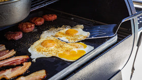 PIT BOSS cast iron griddle with built-in grease trough on the flat side.