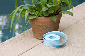 Poolmaster backwash hose rolled flat for compact storage after use.
