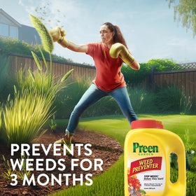 Spreading Preen for even coverage across a flower bed.