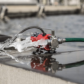 Prostormer Utility Pump in use with hose, transferring water for garden tasks.