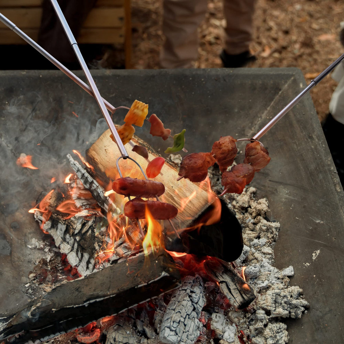 RAOMEIDE patio fire pit cooking with heavy-duty roasting sticks outdoors.