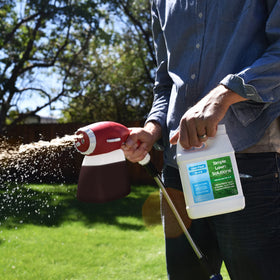 Hose-end sprayer applying Simple Lawn Solutions on turf for even coverage