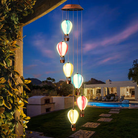 Singingarden solar wind chimes outdoor on fence create a gentle evening glow.