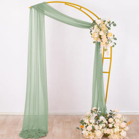 Socomi outdoor arch drapes in sage green create delicate folds