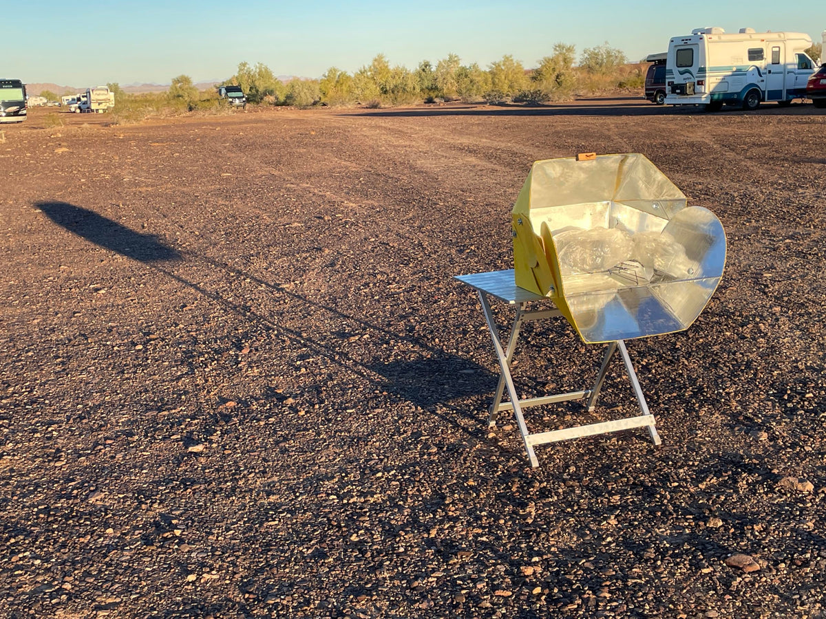 SOL COOK open solar cooker in camping setup for sun-powered meals.