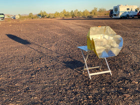 SOL COOK open solar cooker in camping setup for sun-powered meals.
