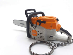 Orange Stihl keyring for keys, featuring a compact chainsaw silhouette