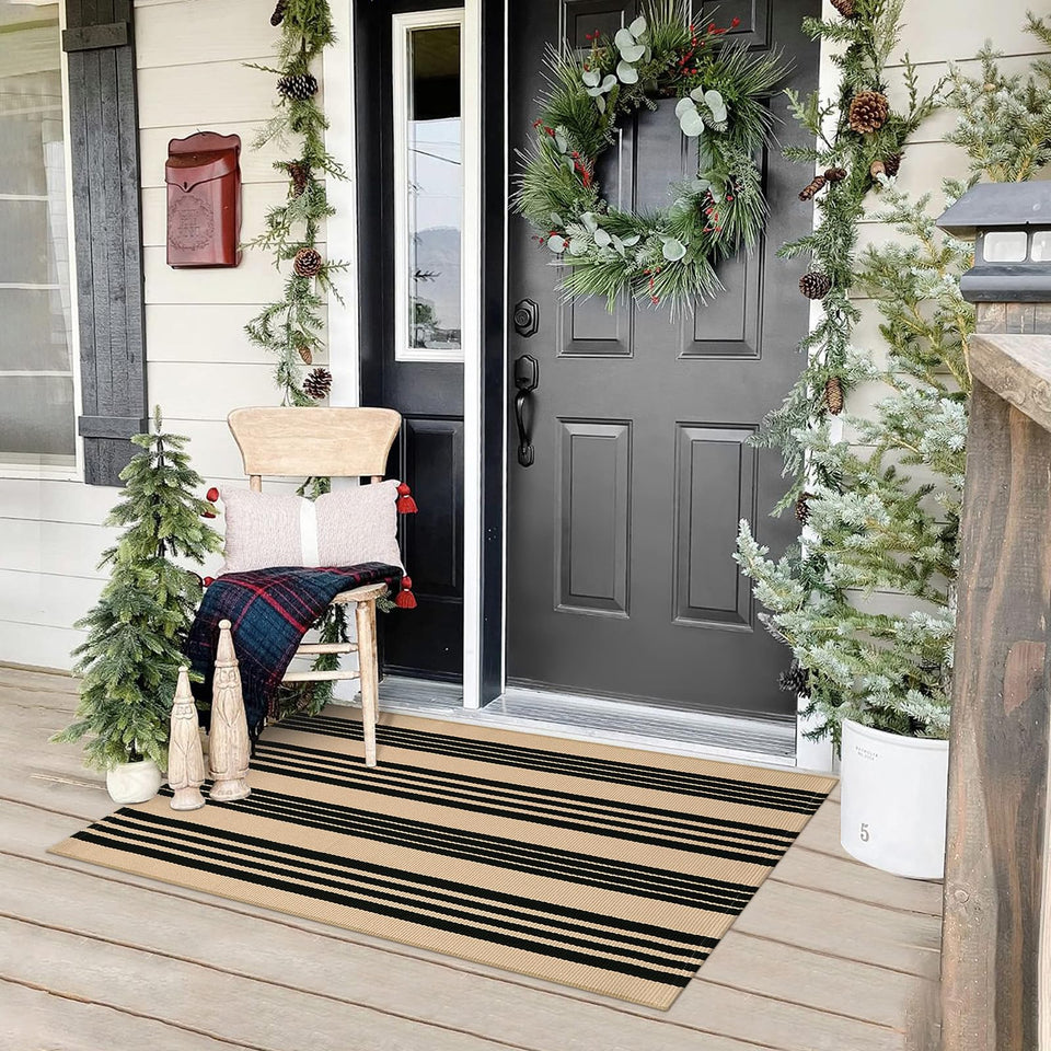 Sungea rug with black and khaki stripes on a front door for welcoming curb appeal.