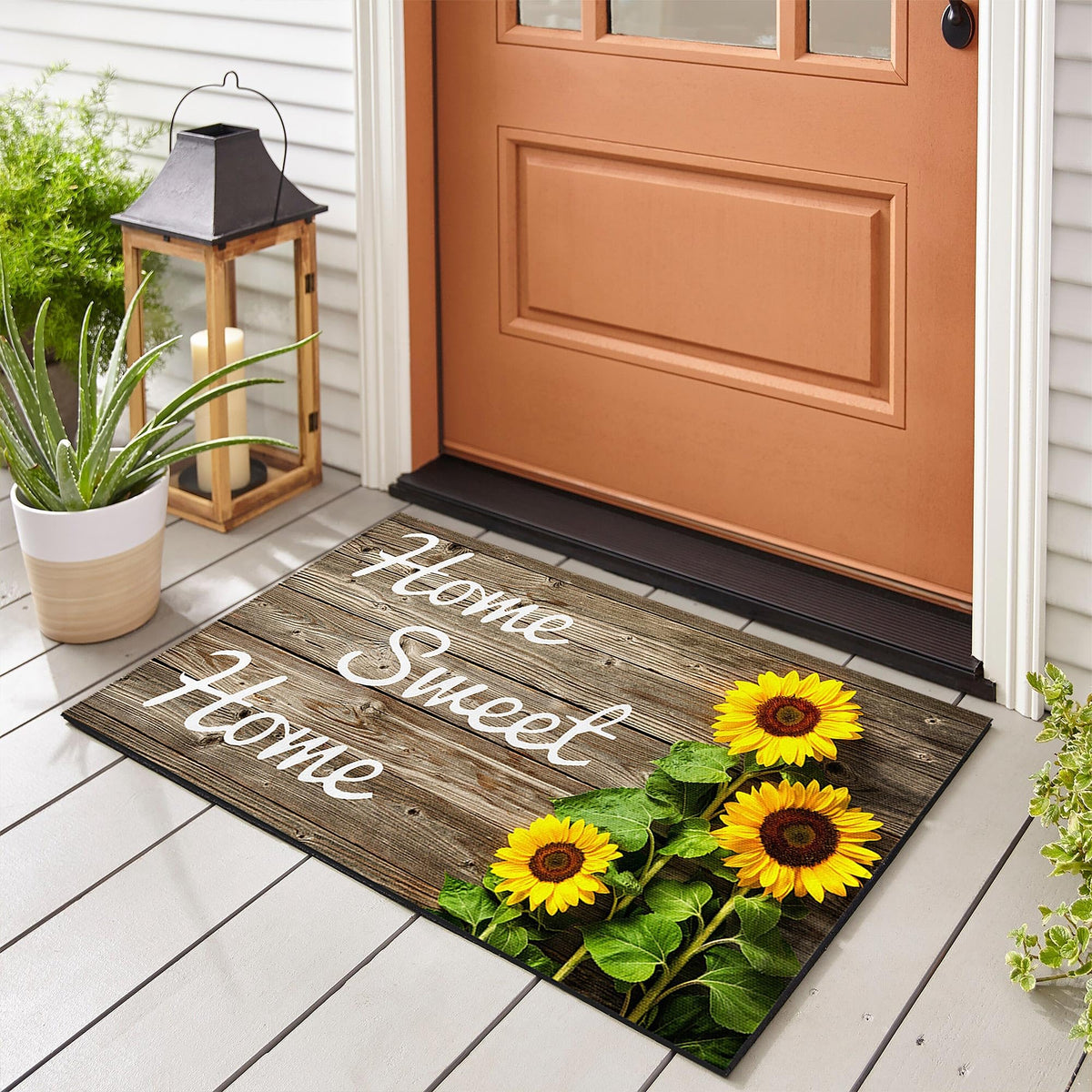 SuQKXCo Sunflower Welcome Doormat front porch with wood background, inviting entry.