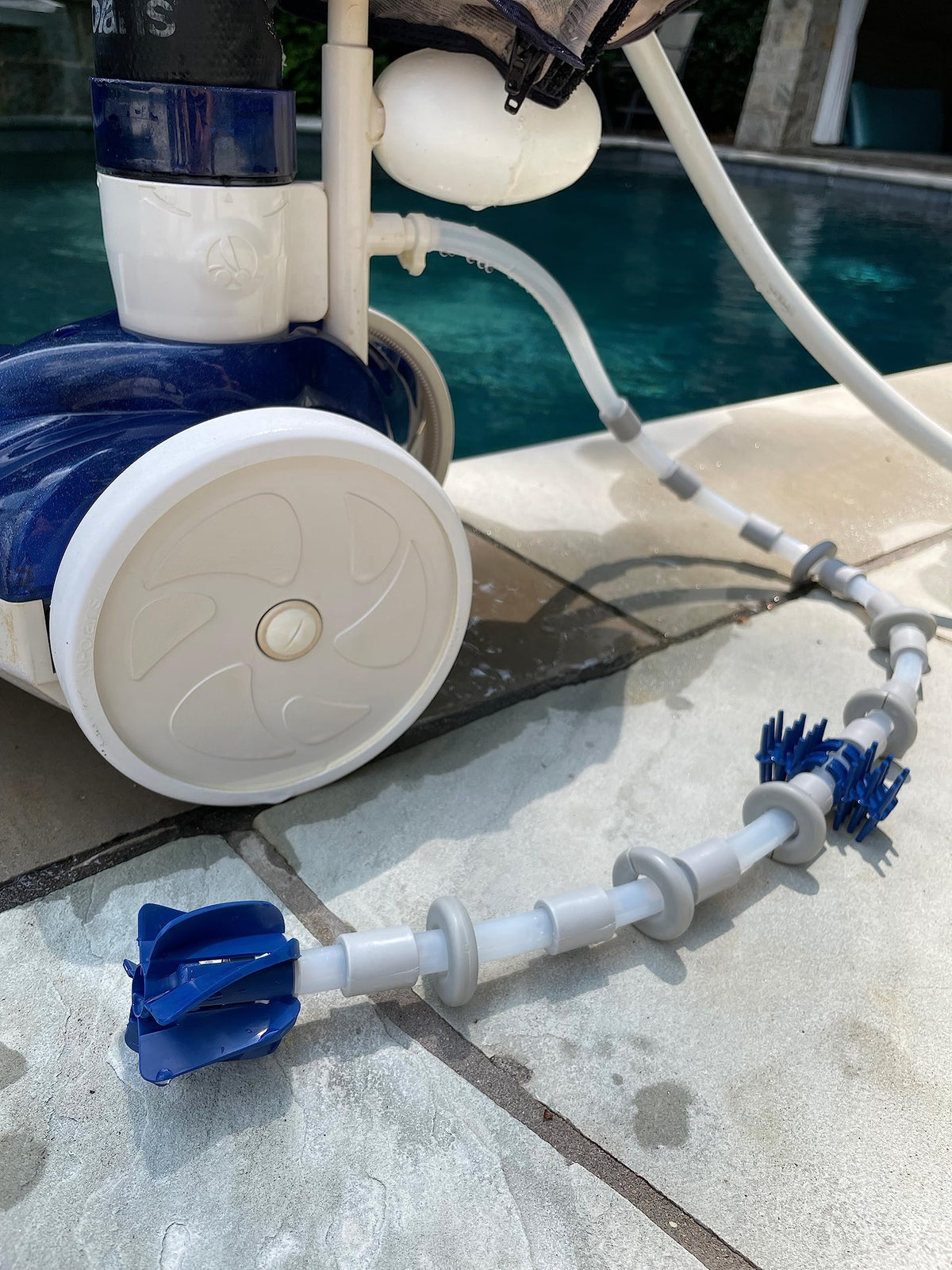 Swasher tail sweep hose in action cleans waterline and walls efficiently.