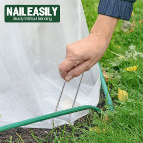TiTifield weed barrier securing stakes shown anchoring fabric and turf areas