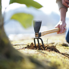 Tomerry garden hoe in garden bed demonstrating precise soil loosening and weed control.