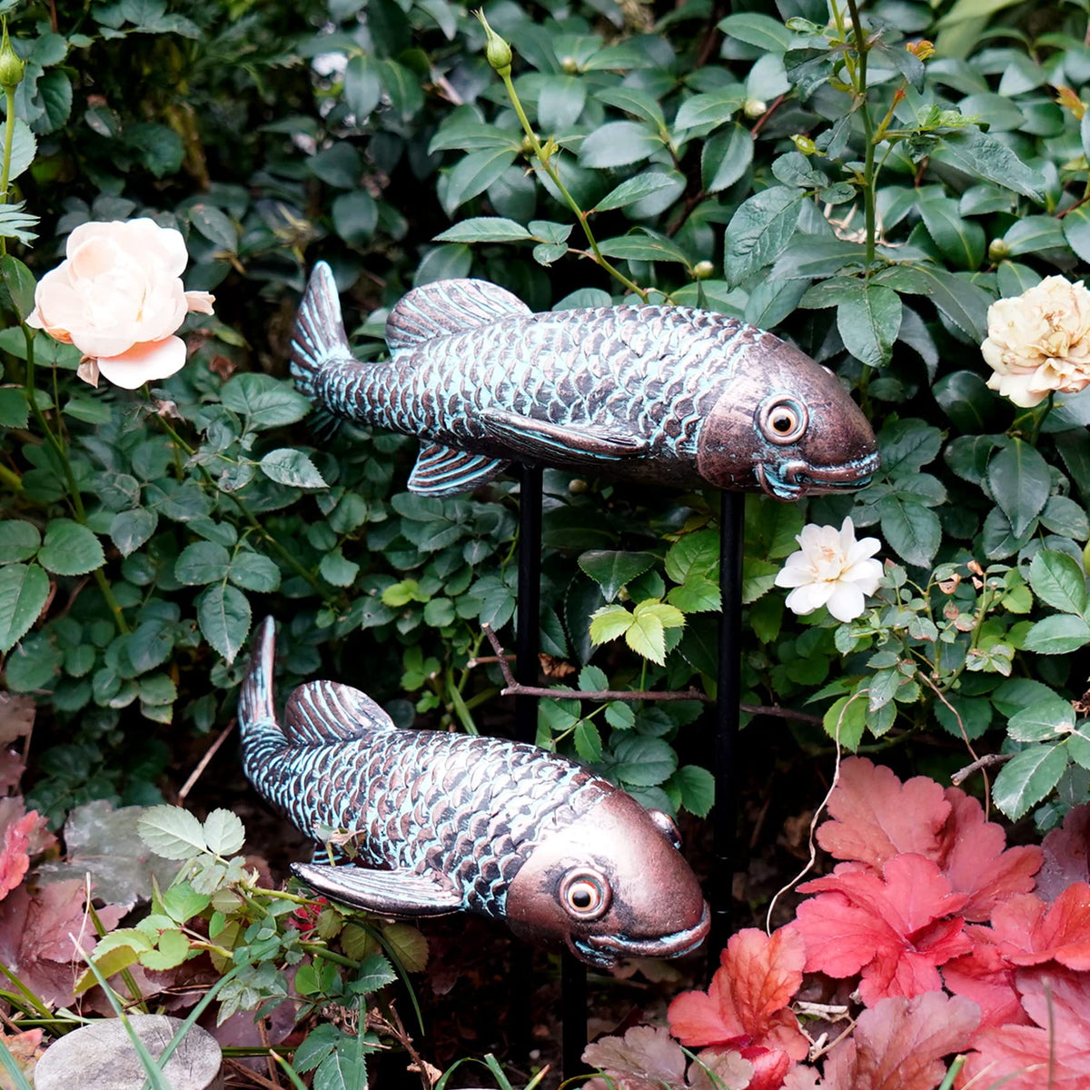 Tooyuart antique koi decor in garden bed adding charm.