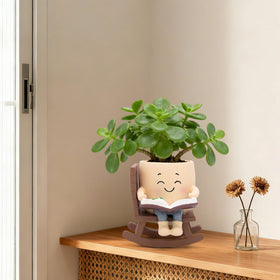 Toparad rocking-chair planter with floral head detail offers whimsical decor.