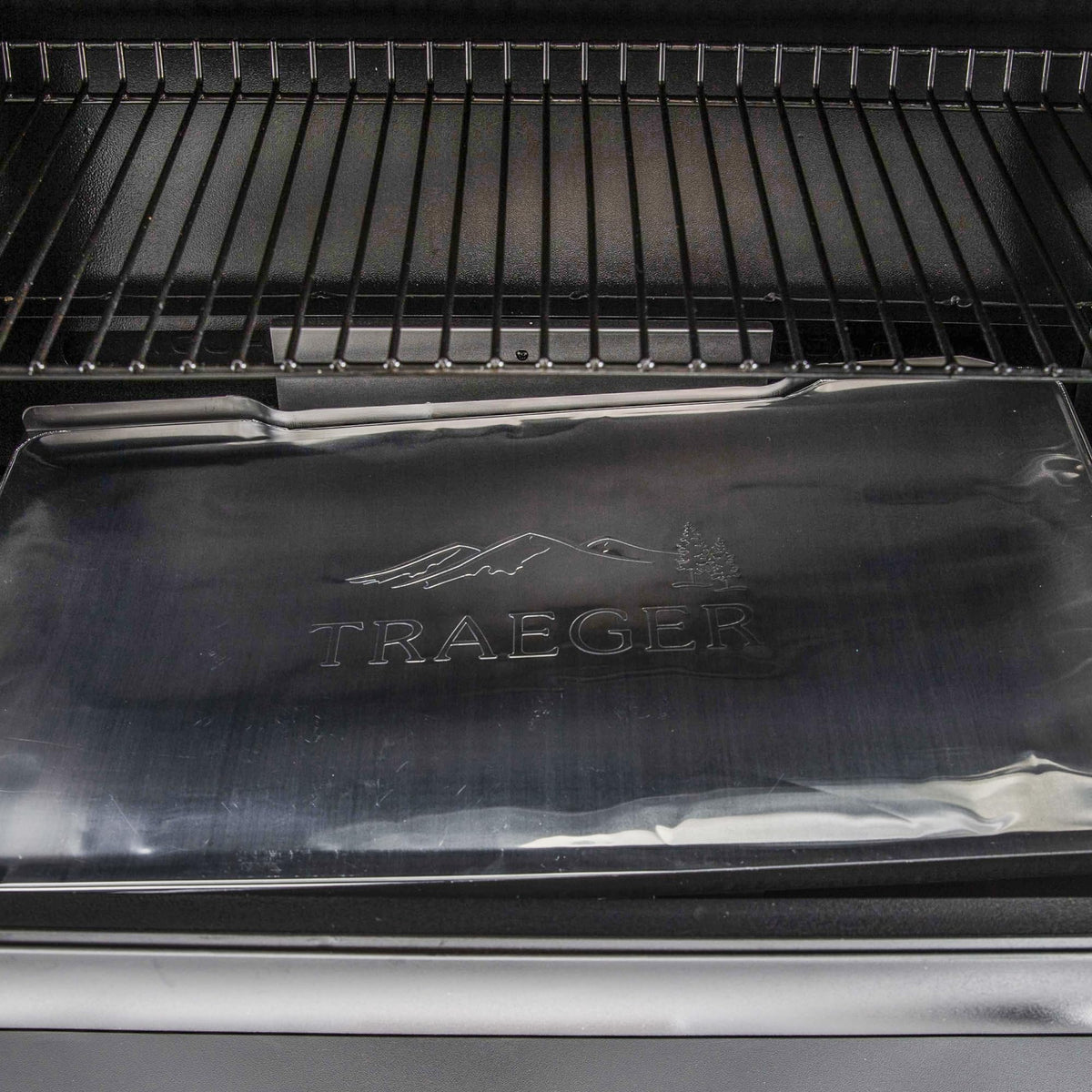 Traeger heat-resistant aluminum liner catching drips to protect grill surface.