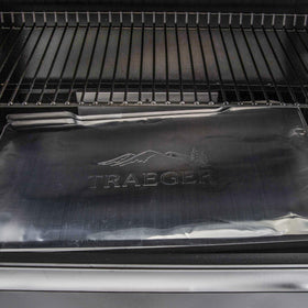 Traeger heat-resistant aluminum liner catching drips to protect grill surface.