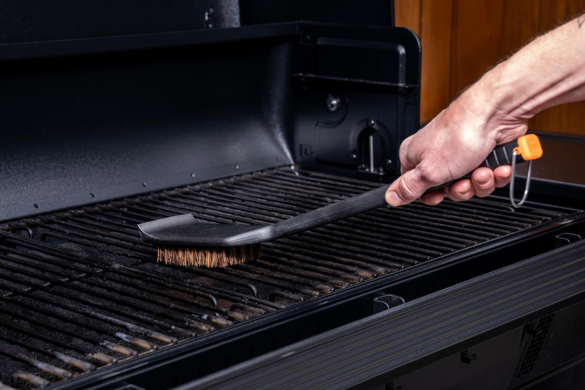 Outdoor-grade handle on Traeger brush for durable outdoor cleaning.