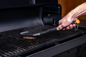 Outdoor-grade handle on Traeger brush for durable outdoor cleaning.