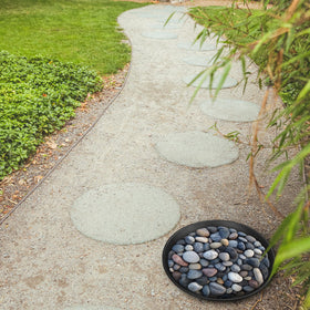 U0U finished painted stepping stones enhance a lush backyard setting.