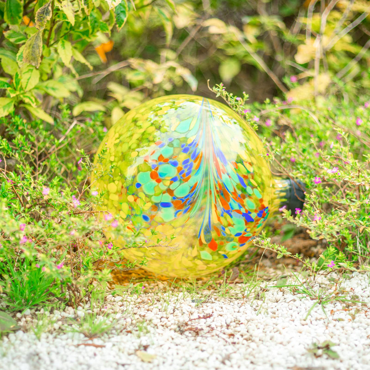 VCUTEKA Gazing Ball yellow swirl 10in placed in a garden setup for color accents.