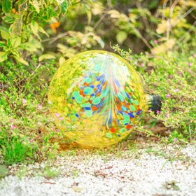 VCUTEKA Gazing Ball yellow swirl 10in placed in a garden setup for color accents.