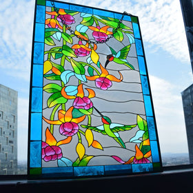 Close-up of VEWOGARDEN hummingbird stained glass with red flowers