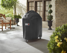 Weber 26-inch charcoal grill cover, side view, water-resistant protection against rain.