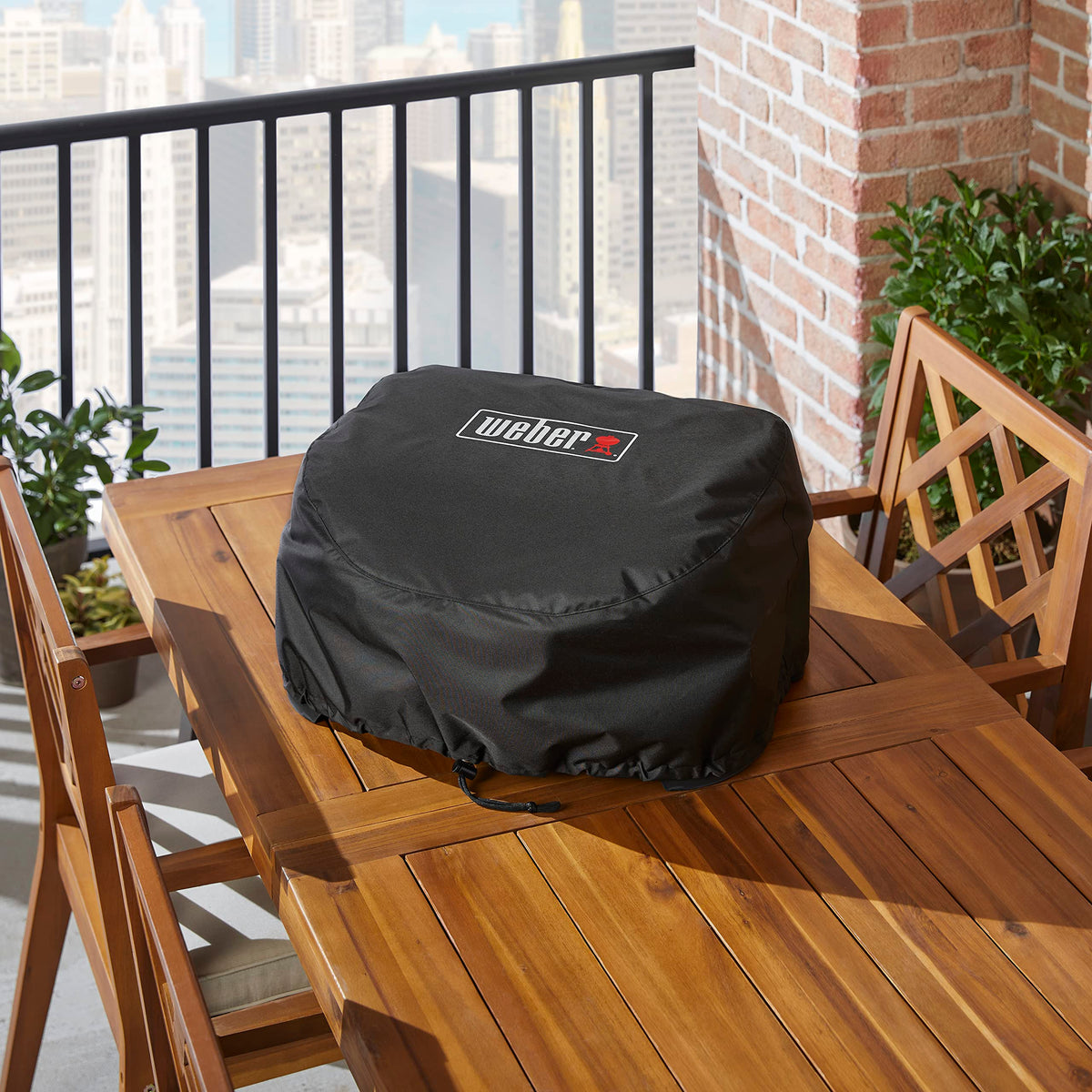 Weber Lumin cover with dual drawstrings secures snug fit on grill.