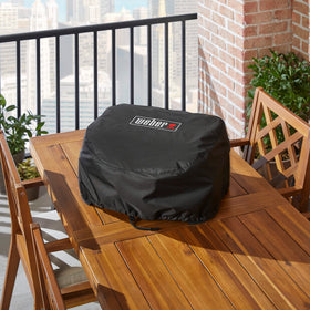 Weber Lumin cover with dual drawstrings secures snug fit on grill.