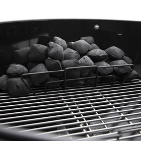 Charcoal rails organize fuel for direct searing and indirect cooking.