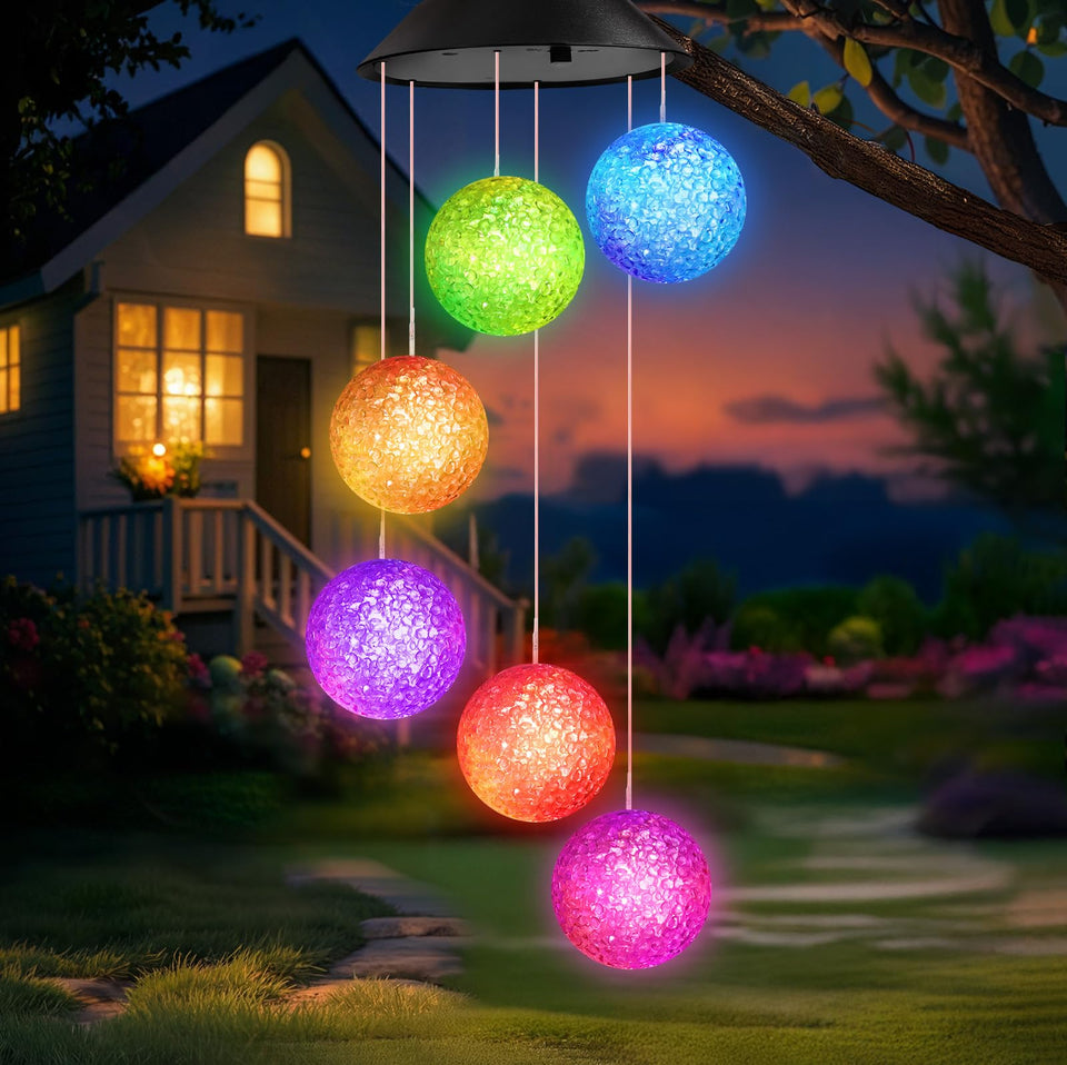Winzwon solar ball wind chime in garden decor illuminating the yard at night.