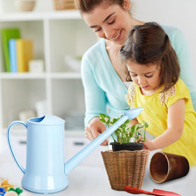 XXXFLOWER blue watering can on windowsill showcases stylish indoor garden decor