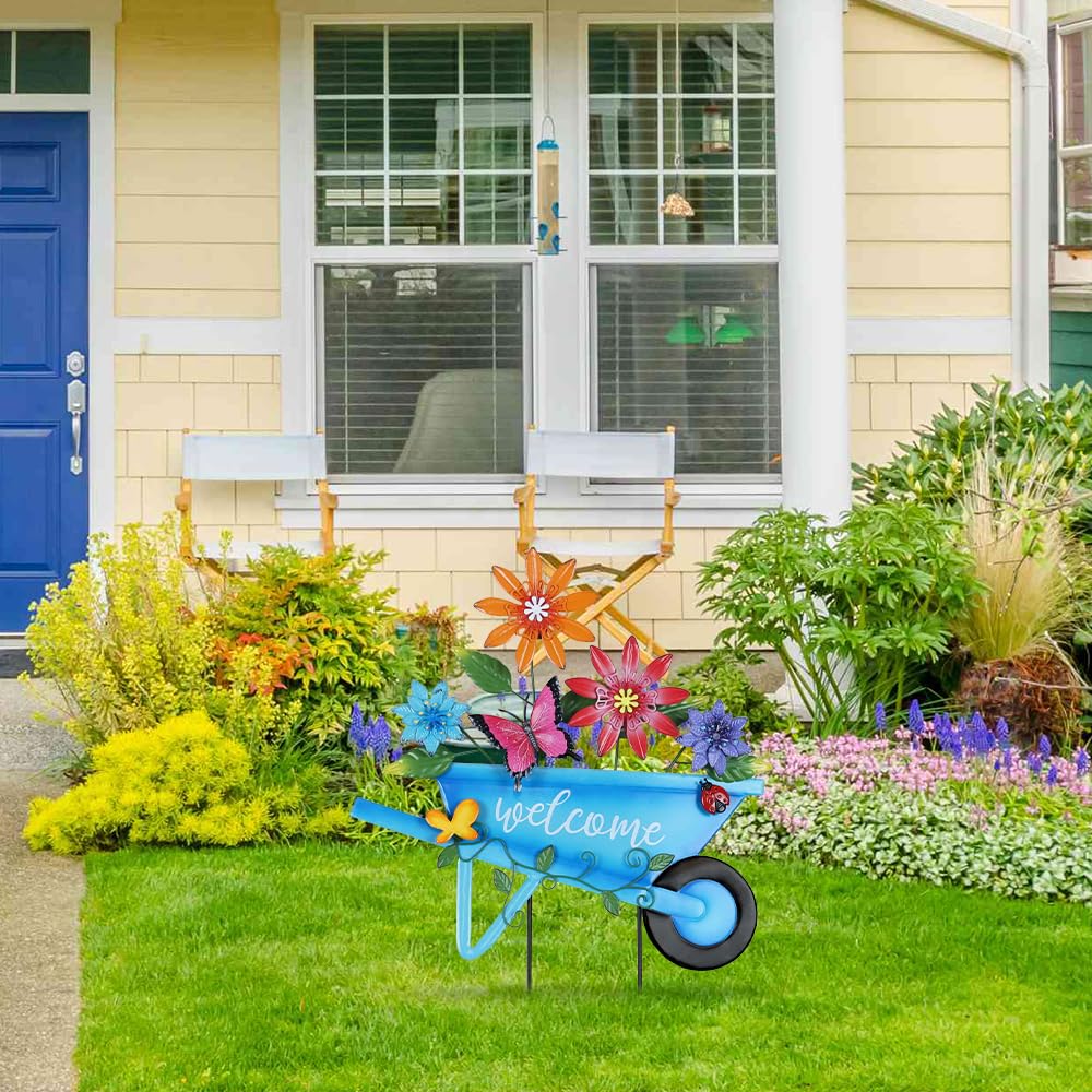 YEAHOME garden stake 25in blue wheelbarrow blends with flowers and greenery.