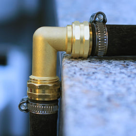 YELUN solid brass elbow shown relieving RV water hose strain.