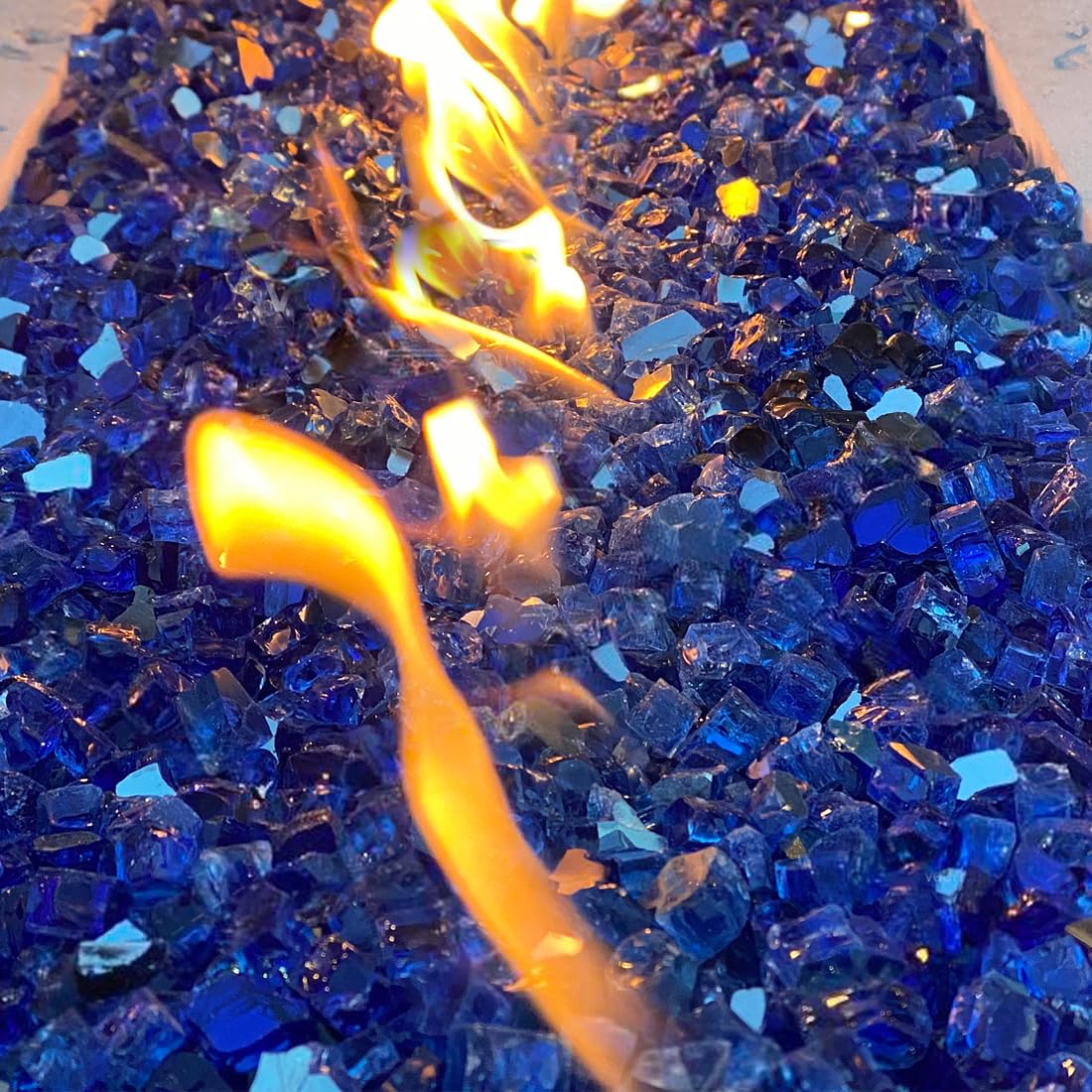YISZM cobalt blue fire glass on an outdoor fire table creates ambient glow.